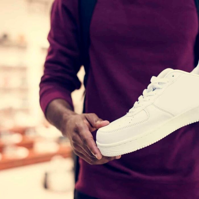 African man holding a white sneaker