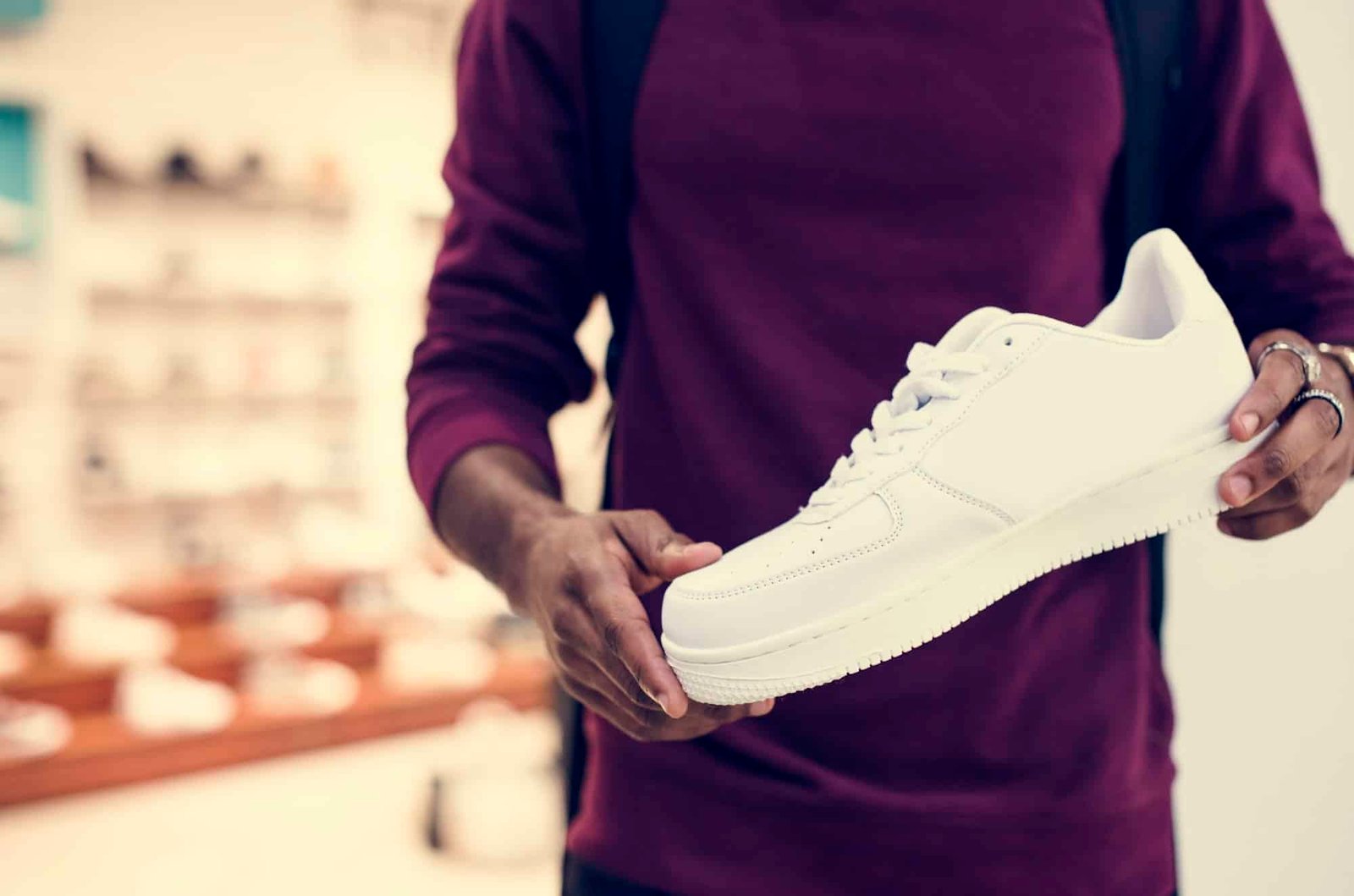 African man holding a white sneaker