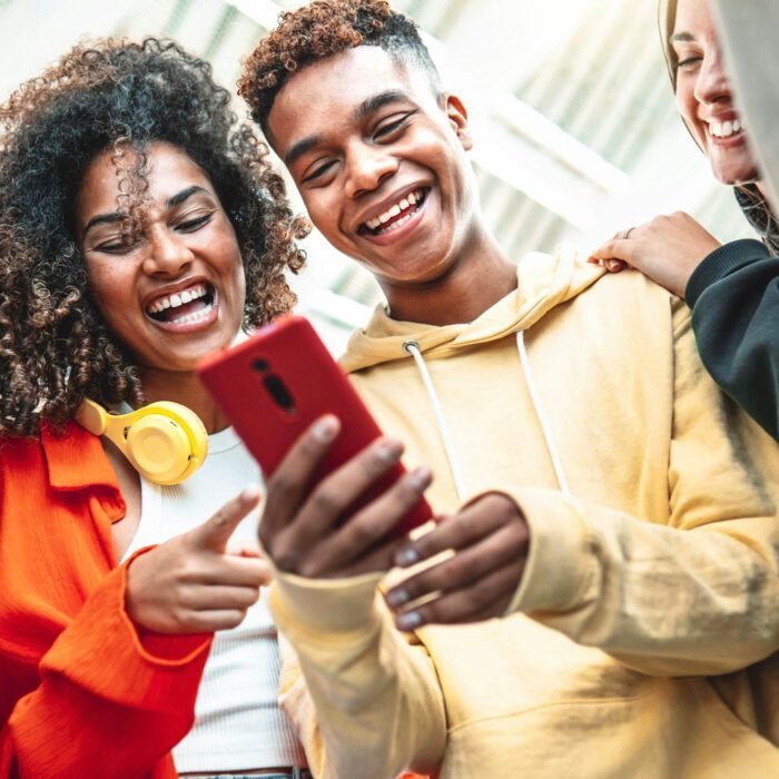 Young people using smart mobile phone device outdoors